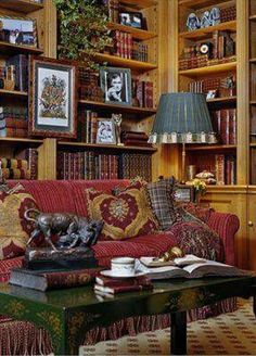 a living room filled with lots of furniture and bookshelves full of books on top of them