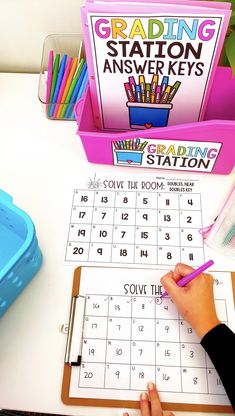 a person is writing on a calendar with colored pencils in front of the station