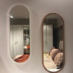 there are two oval mirrors on the wall