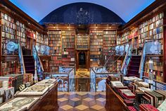 a room filled with lots of books on top of wooden shelves next to each other