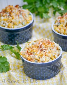 three blue bowls filled with macaroni and cheese on top of a yellow table cloth