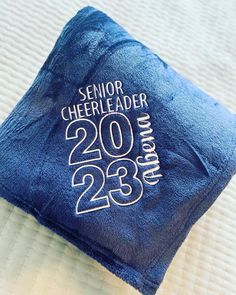 a close up of a blue towel on top of a bed with the words senior cheerleader printed on it