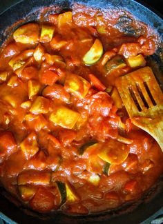 a skillet filled with food and a wooden spoon