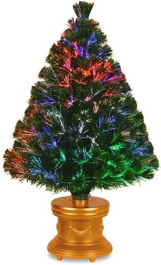 a brightly lit christmas tree sitting on top of a gold pedestal in front of a white background