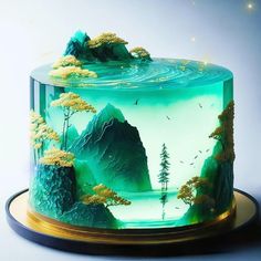 there is a cake decorated with an image of trees and mountains in the glass case