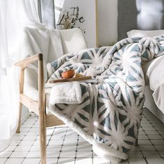 a tray with an egg on it sitting on a bed next to a blanket and chair