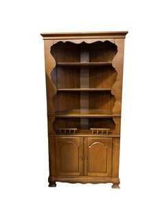 an old fashioned wooden china cabinet with glass doors and shelves on the front, isolated against a white background