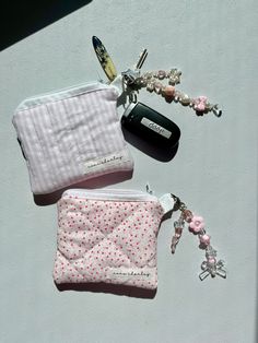 two small purses are laying on the ground next to each other with keys hanging from them