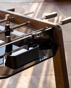 a close up of a foosball table with two cups on the bottom shelf