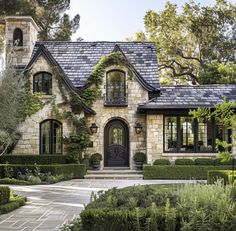 a house that is surrounded by bushes and trees