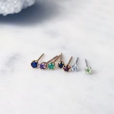 Each pair of these tiny gemstone studs are extra small, dainty and perfect for everyday wear. Choose from Blue Sapphire, Amethyst, Emerald, Peridot, Red Garnet, White Topaz and Black Spinel. Hand set with round, faceted gemstones into 6-prong stud settings.  * 2mm brilliant cut gemstones * 14K Gold filled or Sterling silver settings Photos 4-6 show the difference in size between our mini 2mm and 3mm gemstone studs. This item features genuine, natural gemstones and therefore colour, markings and Black Gems, Earring Gift, Gemstone Stud Earrings, Tiny Stud Earrings, Birthstone Earring, Gift For Girls, Gemstone Studs, Precious Gems, Faceted Gemstones