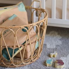 a basket filled with brown paper bags next to two small wooden blocks on the floor