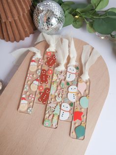 some decorations are sitting on top of a wooden cutting board with paper and tape around them