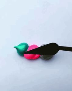 two plastic birds sitting on top of each other next to a pair of black scissors