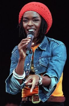 a woman wearing a red knitted hat and holding a microphone in front of her