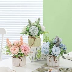 three vases filled with flowers sitting on top of a table