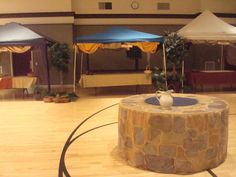 a large room with tables and umbrellas set up for an event in the center