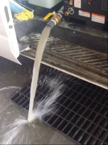 a person is pouring water into a metal grate