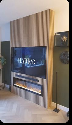 a living room with a large television mounted on the wall next to a fire place