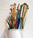 a white vase filled with lots of different colored pencils