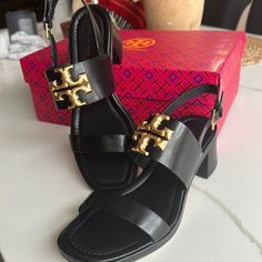 Crafted Of Rich Leather, Tory Burch's Eleanor Sandals Are Highlighted With Signature Double T Logo Hardware. This Square-Toe Pair Is Anchored By A Stacked Block Heel. Leather Upper Open Toe Ankle Buckle Strap Leather/Rubber Sole Imported Size Stacked Block Heel, 2" (55mm Designer Slingback Sandals With Ankle Strap, Designer Slingback Sandals With Heel Strap, Luxury Slingback Sandals With Padded Block Heel, Designer Slingback Heels With Heel Loop, Luxury Slingback Sandals With Branded Heel Counter, Luxury Black Slingback Sandals With Leather Sole, Black Luxury Slingback Sandals For Formal Occasions, Luxury Formal Slingback Sandals With Heel Loop, Luxury Black Slingback Sandals For Formal Occasions