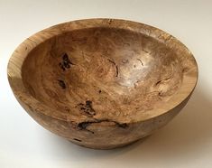 a wooden bowl sitting on top of a white table