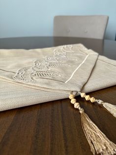 a wooden table topped with a napkin and tassels