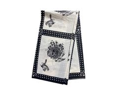 two napkins with black and white designs on them, one is folded to the side