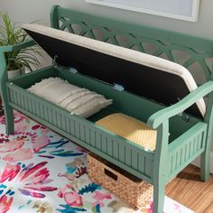 a green bench with two baskets underneath it on a floral rug in front of a window