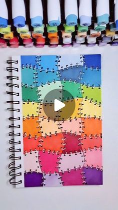 a spiral notebook with several pieces of puzzle on top of it and the video in front of them