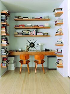 two chairs sitting in front of a desk with books on it