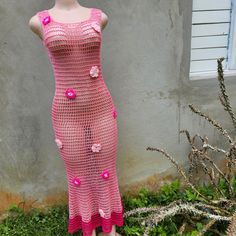 a mannequin wearing a pink crochet dress with flowers on the side