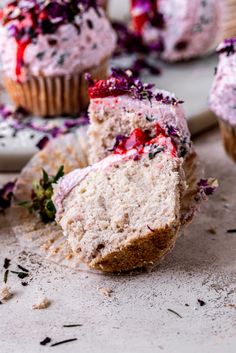 a muffin filled with frosting and sprinkles on top of a table