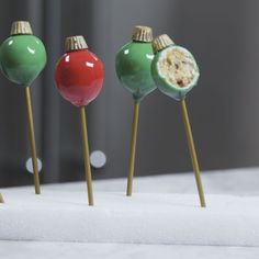 three green, red and gold candy lollipops sitting on top of each other