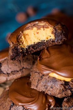 chocolate covered cookies with yellow frosting and peanut butter in the middle, stacked on top of each other