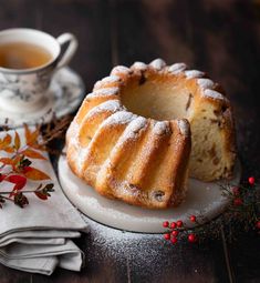 a bunt cake sitting on top of a white plate next to a cup of tea