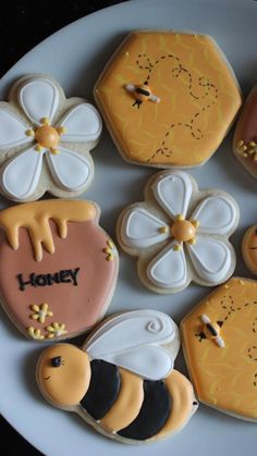 decorated cookies are arranged on a plate with the words honey written in frosting next to them