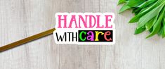 a sticker that says handle with care on it next to some green leaves and chopsticks