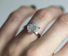 a close up of a person's hand with a diamond ring on their finger