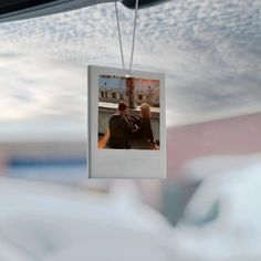 two people are sitting on a bench and one is hanging from the ceiling