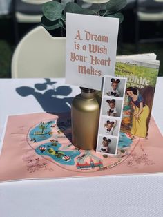 there is a card and vase on top of a table with a sign that says, a dream is a wish your heart makes