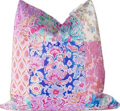 a pink and blue pillow with an ornate design on the front, sitting against a white background