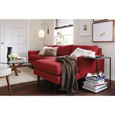 a living room with a red couch and coffee table