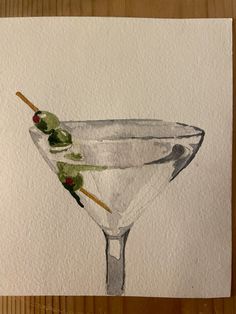 a drawing of a martini glass with olives on the rim and garnish