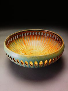 an orange and blue bowl sitting on top of a table