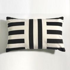 a black and white striped pillow sitting on top of a wall