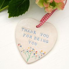 a ceramic heart with the words thank you for being you on it next to flowers