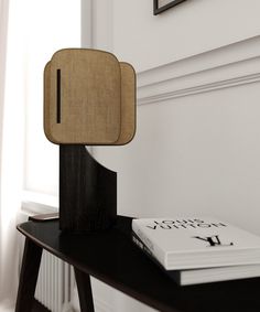 a wooden object sitting on top of a table next to a book