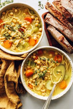 two bowls filled with soup next to bread