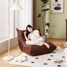 a woman is sitting on a bean bag chair in the living room with her feet up